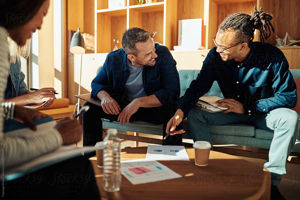 Colleagues talking through plans together in a bright office