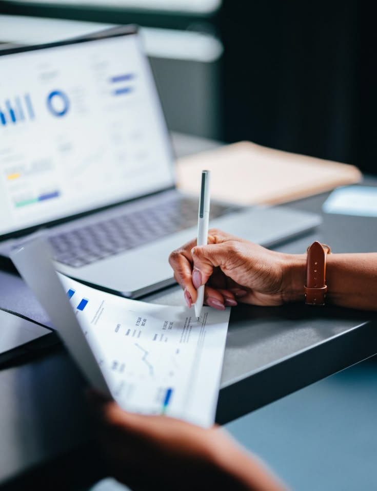 Reviewing financial statements alongside a reporting dashboard